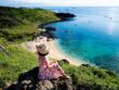 A young girl on a rock and view down in Phu Quy island, Vietnam; Shutterstock ID 2173188527; purchase_order: -; production: -; spv: -; name: -